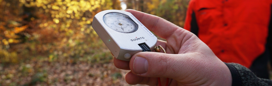 Blick auf ein silbernes Messinstrument mit Ziffernblatt in der Hand eines Studenten